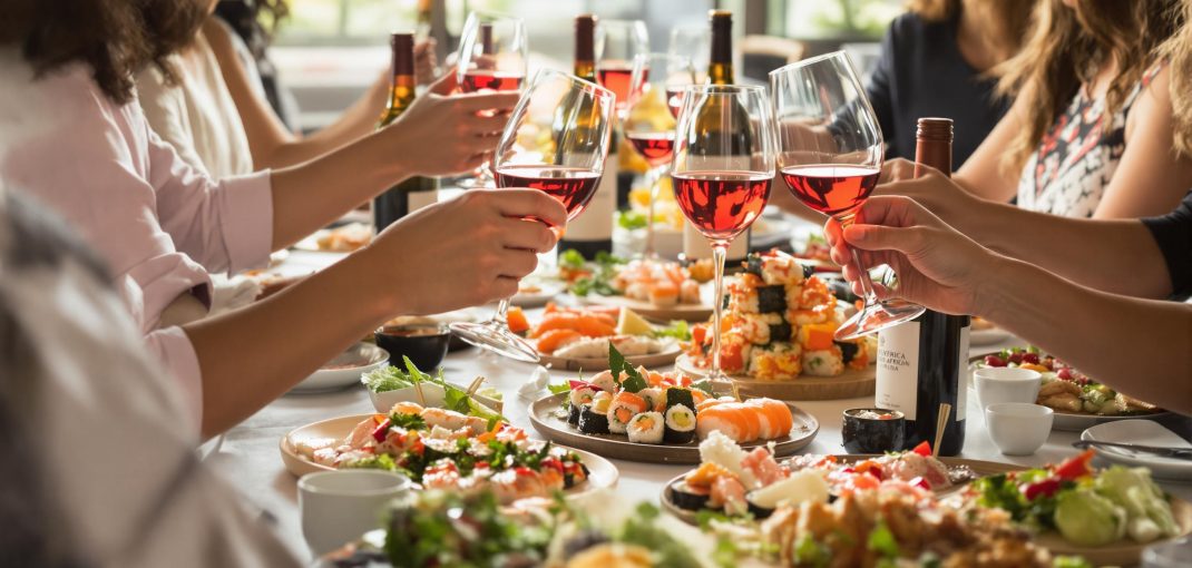 Friends enjoying sushi and South African wine in elegant setting